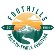 Foothills Rails to Trails Coalition Logo 2024, showing a railroad line turning into a path as it comes from Mt. Rainier toward the viewer